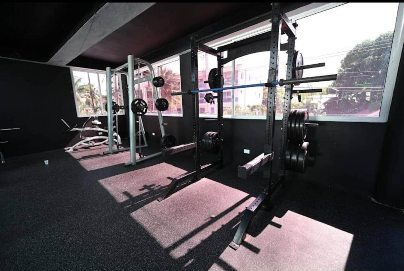 Una palestra con attrezzatura per sollevamento pesi, una finestra e vista all'esterno.