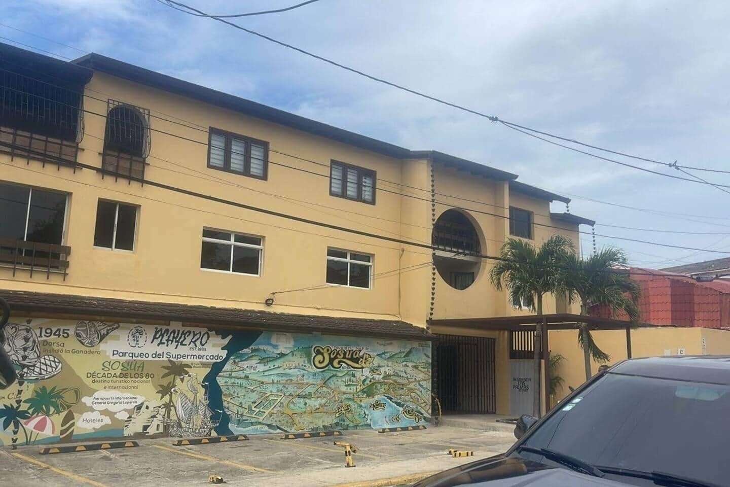 A two-story building with a mural on the side depicting a map and historical elements.