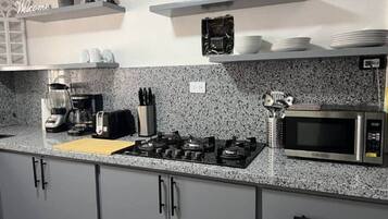 Een koelkast, een magnetron, een kookplaat, een broodrooster