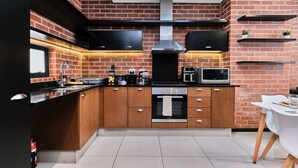 A modern kitchen with a brick backsplash, stainless steel appliances, and a built-in oven.