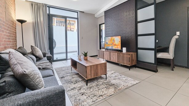 A modern living room with a sofa, coffee table, and TV.