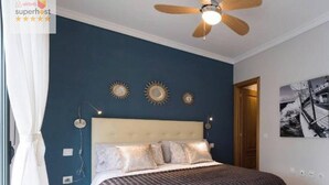 Un dormitorio con cama, ventilador de techo y adornos en la pared.