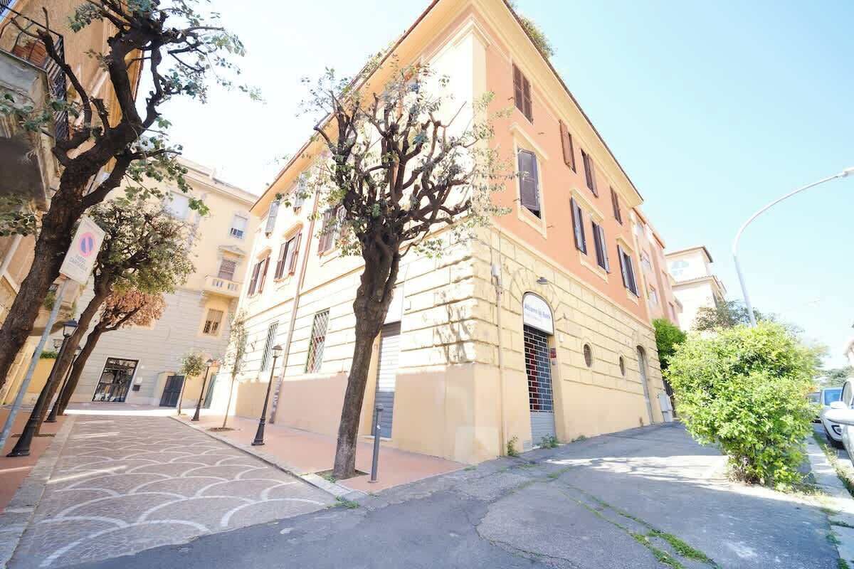 A street with buildings, trees, and a clear sky.