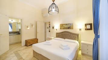Un dormitorio con cama, mesitas de noche, armario y espejo.