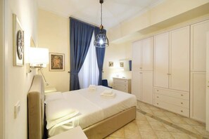 Ein Hotelzimmer mit Bett, Nachttischen, einem Kleiderschrank und einer Pendelleuchte.