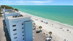 A hotel named Sunset Chateau 8470 with a beach view, a parking lot, and a sandy beach with umbrellas. - Sunset Beachfront Bliss
Wake Up to Waves & Gulf Views!
New heated Pool! (Treasure Island)