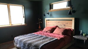 A bedroom with a wooden bed, a window, a nightstand, and a wall-mounted shelf. - A Restful Retreat Just A Stones Throw Away From Downtown  (Quincy)