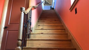 A wooden staircase with a handrail, leading to a landing with a window. - A Restful Retreat Just A Stones Throw Away From Downtown  (Quincy)
