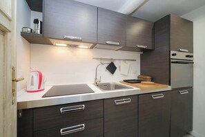 A modern kitchen with a stainless steel sink, a kettle, and a toaster.