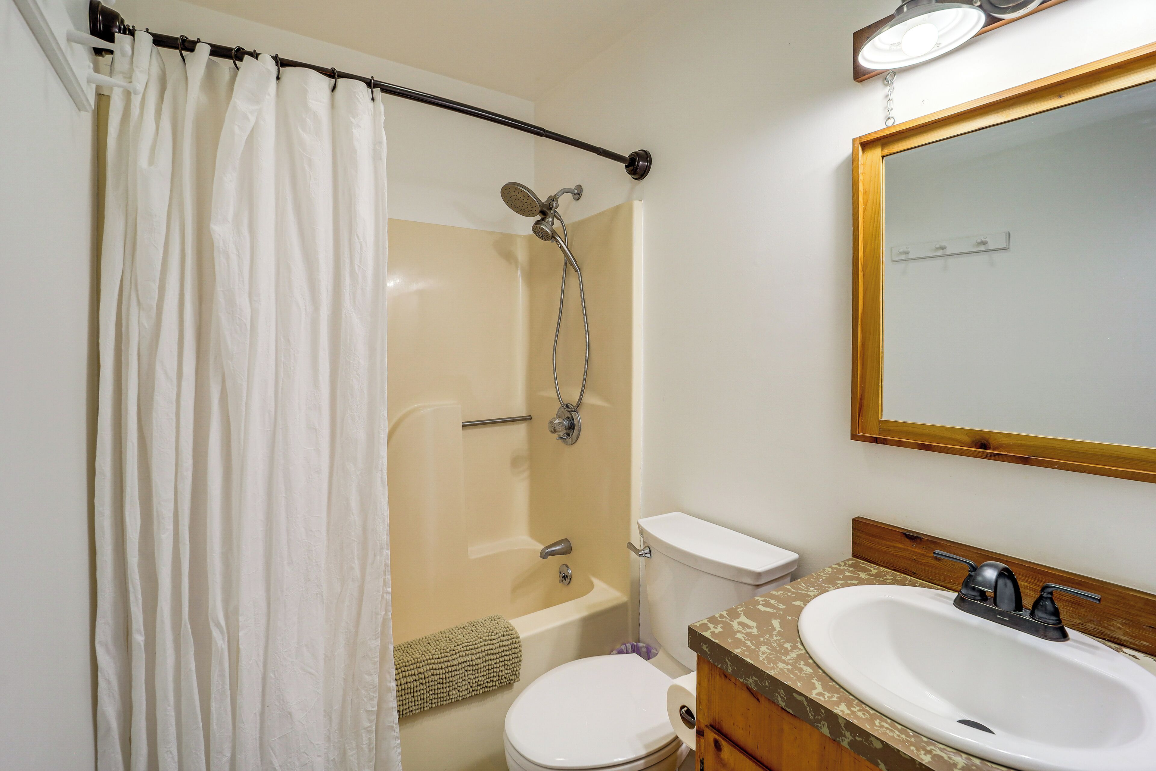Ein Badezimmer mit Dusche, Toilette und Waschbecken.