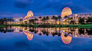 A hotel with two large, illuminated domes, a reflection in the water, and a bridge connecting the domes. - SeaWorld Orlando | Parks & Convention Center (Orange County)