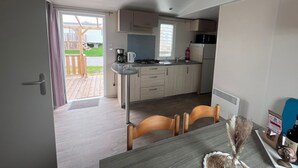 Uma cozinha compacta com área de refeições, uma mesa pequena e vista para a varanda externa.
