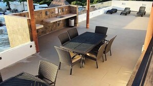 An outdoor patio with a grill, seating area, and poolside view. - Walk to the beach from your luxury living apartment (Playa del Carmen)