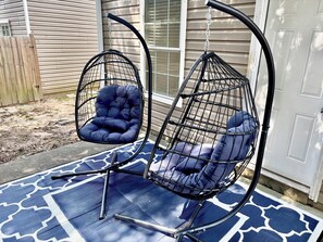 Two hanging chairs with cushions on a blue patterned mat outside a house. - Game House - Hot Tub - Sleeps 10 (Atlanta)