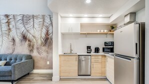 A modern kitchen with a dishwasher, microwave, and refrigerator.