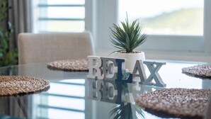Une table en verre avec une plante en pot et les lettres formant le mot « RELAX ».