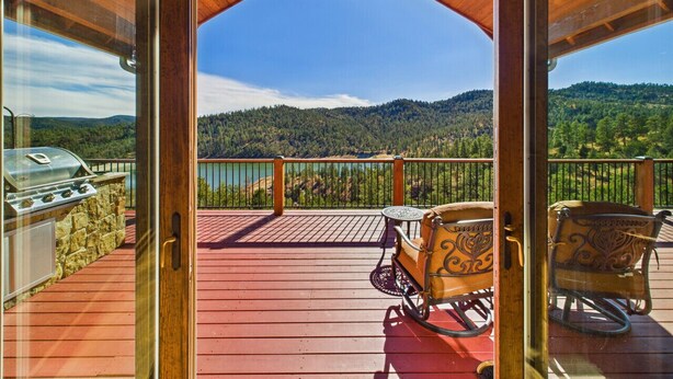 A wooden deck with a view of a lake and mountains. - Grindstone Lake Lodge -Views-Family Reunion Ready (Ruidoso)