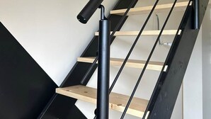 A staircase with black metal railings and wooden steps. - Gite with Spa (Arras-en-Lavedan)