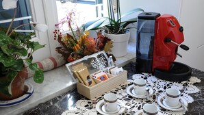 A kitchen counter with a coffee maker, a tray of cups, a coffee bag, and a decorative plant. - B&B La Cascata   Camera Amalfi (AMALFI)