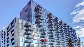 A modern high-rise building with multiple balconies and a glass facade.