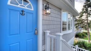 A blue door with a white window above it, a white railing, and a white picket fence in the background. - Bay Avenue Bliss, Newly Updated, Spacious Yard, OCNJ South Shore (Ocean City)