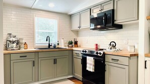 A kitchen with a built-in oven, a microwave, and a coffee maker. - Secluded 2.5-Acre Retreat: Rustic Charm & Modern Comfort in Land O’ Lakes. (Land O' Lakes)
