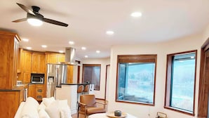 Uma sala de estar moderna com sofá, área de jantar e cozinha.
