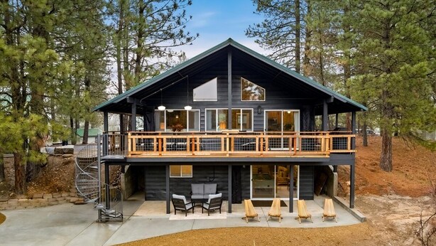 A modern two-story cabin with a balcony, outdoor seating, and a staircase leading to the upper level. - Remodeled Cabin: Golf & Hot Springs (Garden Valley)