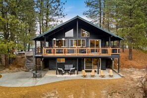 A modern two-story cabin with a balcony, outdoor seating, and a staircase leading to the upper level. - Remodeled Cabin: Golf & Hot Springs (Garden Valley)
