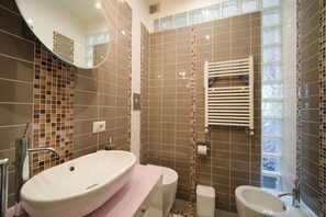 A bathroom with a large sink, a toilet, and a bidet.