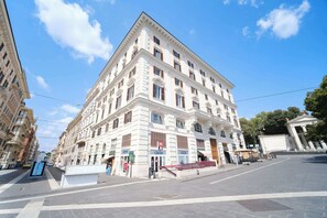 A multi-story building with a classical architectural style, featuring a prominent corner entrance and a series of windows. - BuddyRent - Elinor's Refuge - Flaminio - 3 (roma)