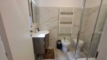 Een douche, een haardroger, een bidet, handdoeken