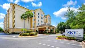 A hotel entrance with a sign reading "Stay SKY Suites Orlando". - Suite near Epic & Universal, Netflix + Parking (Orlando)
