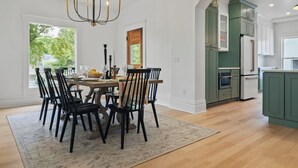 A dining area with a chandelier, a table set for six, and a view of the outdoors.