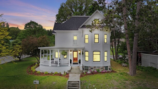 A two-story house with a porch, a stone foundation, and a number '503' on the front door.