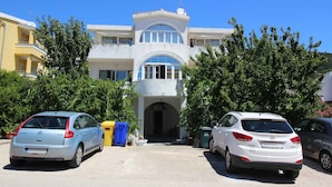 A two-story building with a central entrance and a balcony on the upper floor.
