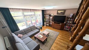 Een woonkamer met een bank, salontafel en boekenkasten.
