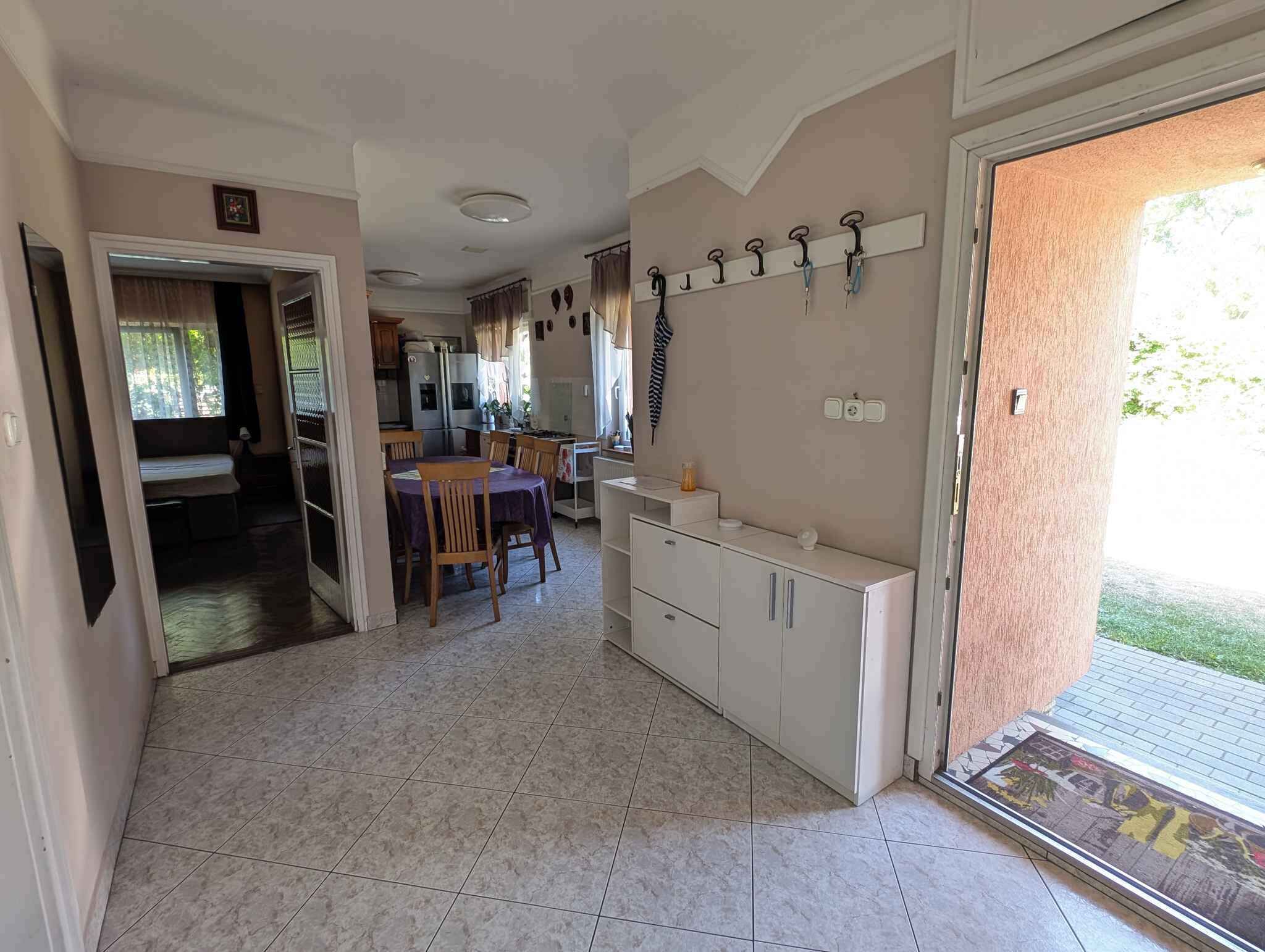 A spacious kitchen with a dining area, a built-in oven, and a large window.