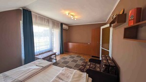 Een kamer met twee bedden, een bankje, een kast en een kleine tafel.