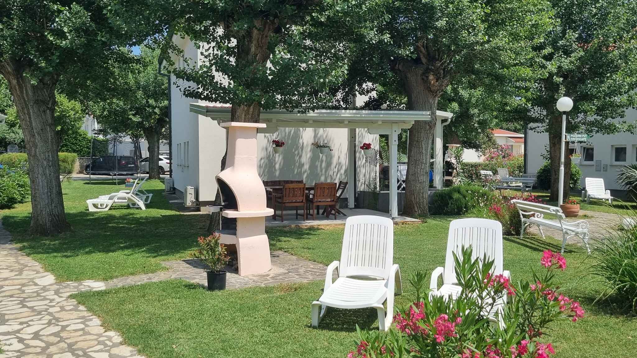 Un jardí amb una glorieta, seients a l'aire lliure i un camí de pedra.