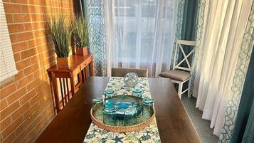 Ein Essbereich mit einem langen Tisch, dekorativem Glas und einer verzierten Tischläufer.
