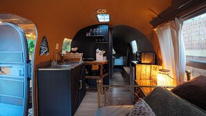 Une cuisine compacte équipée d’un four à micro-ondes, d’un évier et de divers ustensiles de cuisine.