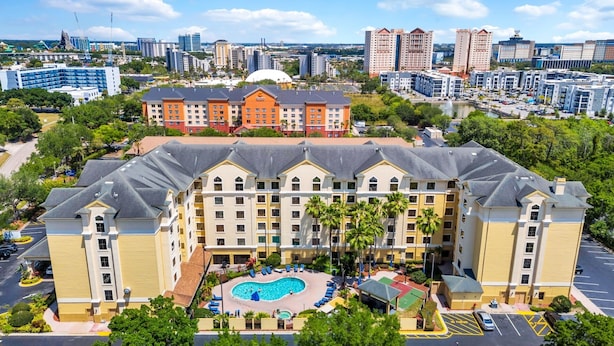 A hotel with a central courtyard, a swimming pool, and a view of the city skyline. - Near Epic Universe & Universal, +parking & Netflix (Orlando)