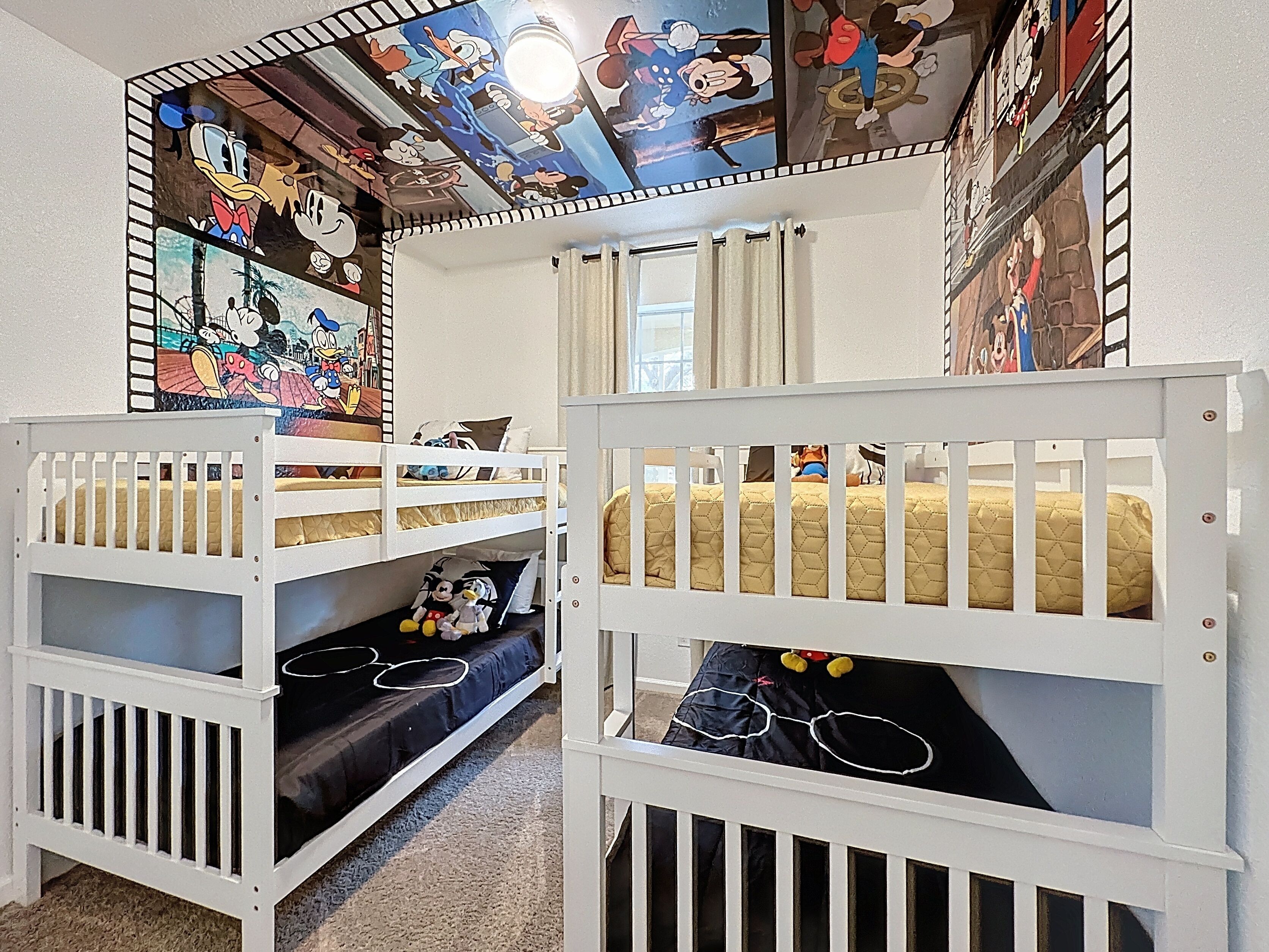 A child's bedroom with bunk beds, a ceiling mural, and a window.