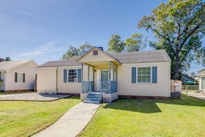 A single-story house with a front porch, a small front yard, and a clear sky.