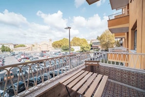 Un balcón con vistas a un estacionamiento y edificios.