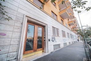 A building with a large wooden door, a visible 'JM' sign, and a balcony.