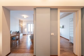 Un pasillo con comedor, escalera y vista al exterior.