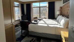 A hotel room with a large bed, a chair, a desk, and a view of a mountain. - Martin LutherKing ski break! Beaver Creek ski weekend. 2 bedroom condo (Avon)