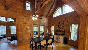 A spacious wooden cabin with a dining area, kitchen, and large windows. - Peaceful mountain cabin with amenties in Rumbling Bald resort, Lake Lure (Lake Lure)